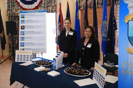 Kathleen Vazquez (left) and Melissa Velasco of Naval Surface Warfare Center Corona Division's Performance Assessment division prepare to greet employees at an annual Corona University rally event. Vazquez and Velasco serve as volunteer mentors for the Corona University program, providing employees interested in career development and continued learning with information on available courses.