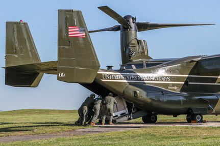 Marine Corps members from the Presidential Helicopter Squadron (HMX-1) load a Joint Modular Intermodal Container (JMIC) onto a MV-22B after landing at the helipad at Naval Surface Warfare Center Indian Head Division (NSWC IHD), May 18. The NSWC IHD Cartridge Actuated Devices/Propellant Actuated Devices (CAD/PAD) enterprise was notified there was an impact to a U.S. Marine Corps MV-22B attached to the Presidential Helicopter Squadron, May 17. Due to the impact, the aircraft was grounded at a deployed location and submitted an emergency order for several CADs. The unique route in transit from the home location of HMX-1 to the deployment location indicated a stopover at NSWC IHD would be more advantageous compared to standard ground shipment. Through coordination with NSWC IHD leadership, an MV-22B landed at the command’s helipad on the morning of May 18, where a pallet of replacement assets was waiting to be loaded onboard.