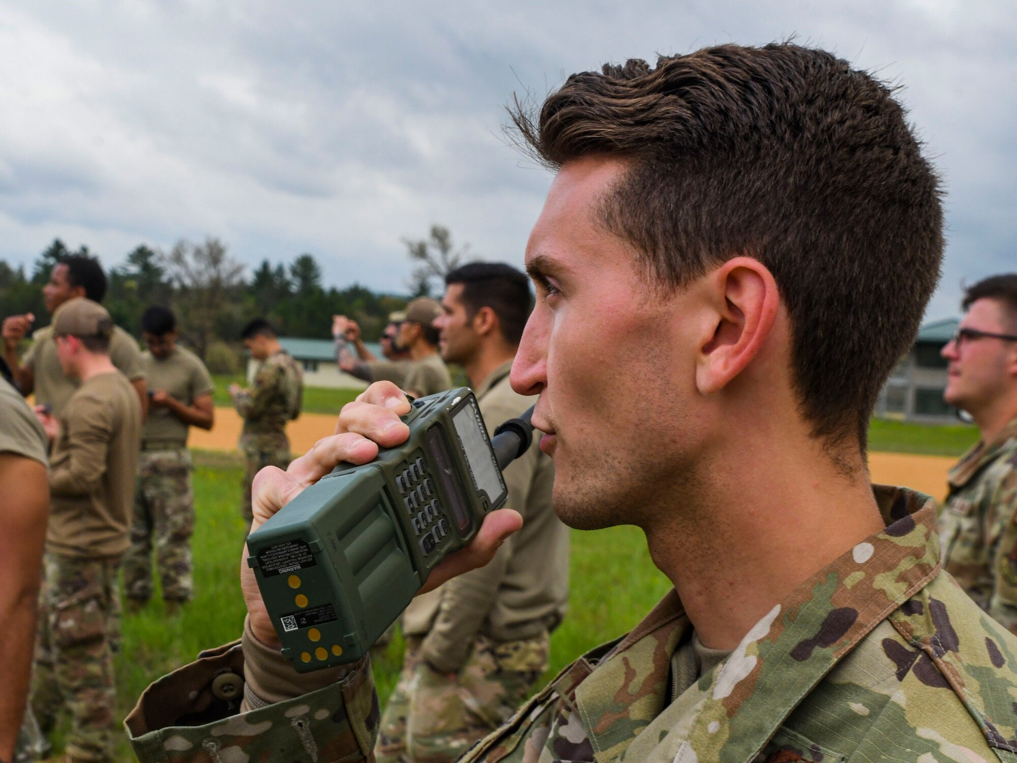 A photo of an airman talking on a radio