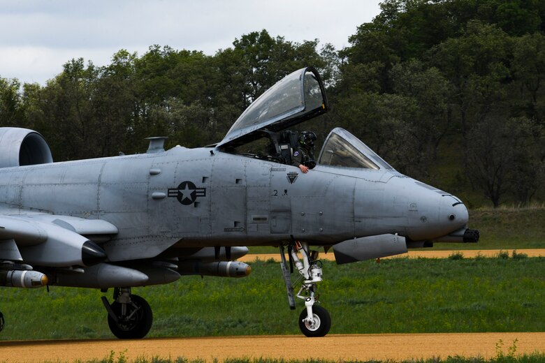 A photo of an aircraft taxing on a dirt runway