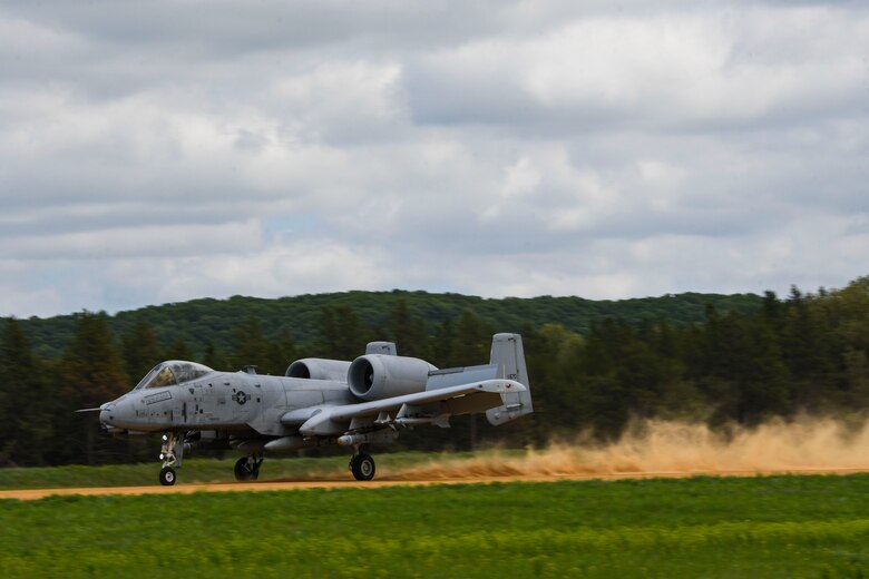 A photo of an aircraft landing on a dirt runway