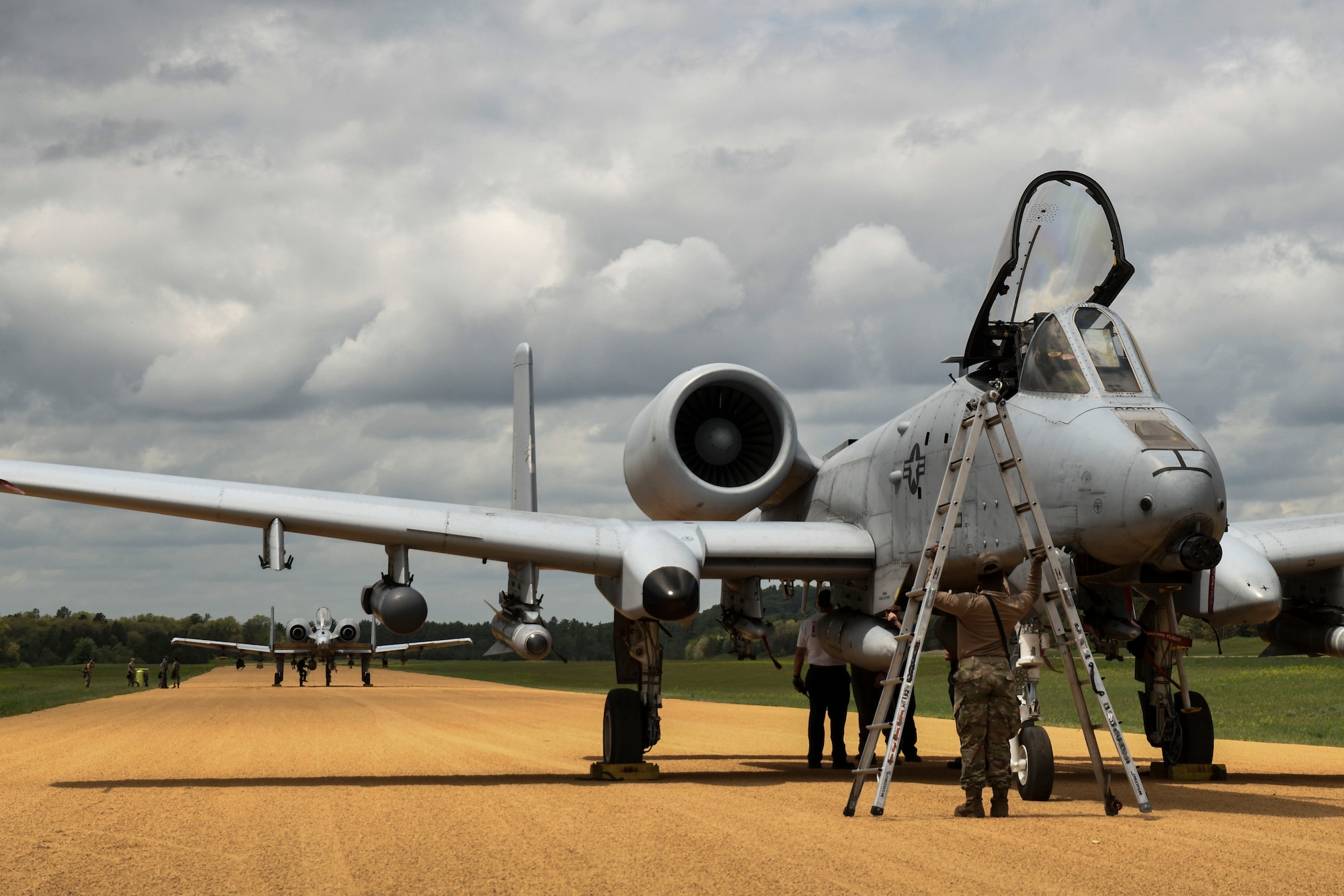 A photo of an aircraft on a dirt runway