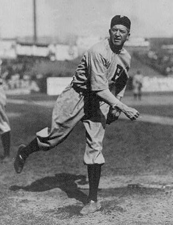 A historic photo of a man pitching a baseball.