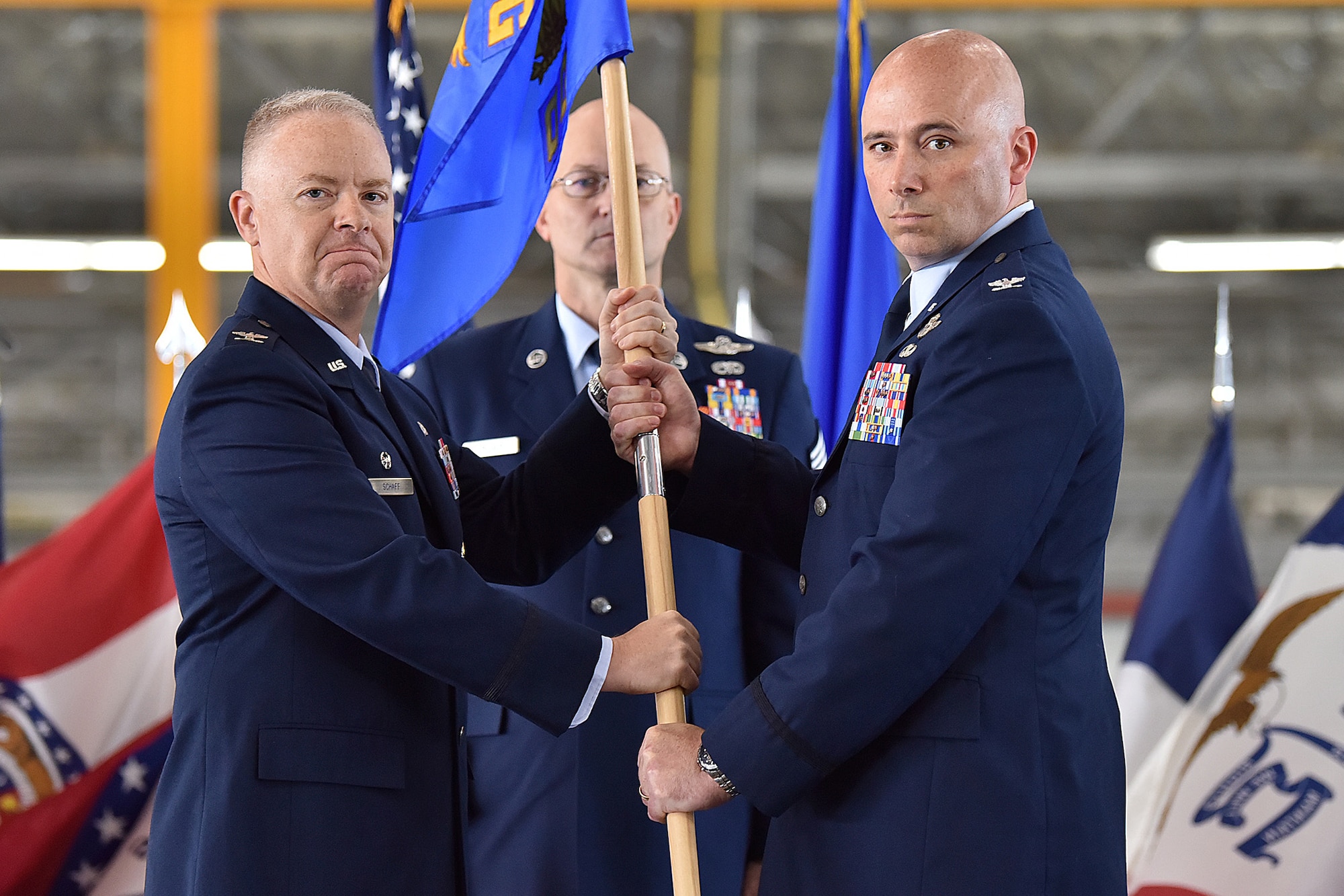 Col. John Ross, right, accepts command of the 316th Operations Group by taking the guidon from Col. Tyler Schaff, 316th Wing and installation commander, during a change of command ceremony, June 10, 2021, at Joint Base Andrews, Md. Chief Master Sgt. Harold Kruger, 316th Operations Group superintendent, looks on. Organizational flags were developed with color arrangements and symbols unique to each particular unit. (U.S. Air Force photo by Senior Airman Daniel Brosam)