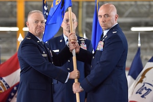 Col. John Ross, right, accepts command of the 316th Operations Group by taking the guidon from Col. Tyler Schaff, 316th Wing and installation commander, during a change of command ceremony, June 10, 2021, at Joint Base Andrews, Md. Chief Master Sgt. Harold Kruger, 316th Operations Group superintendent, looks on. Organizational flags were developed with color arrangements and symbols unique to each particular unit. (U.S. Air Force photo by Senior Airman Daniel Brosam)