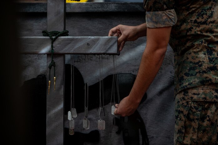 A U.S. Marine with 2d Battalion, 6th Marine Regiment 2/6, 2nd Marine Division, hangs dog tags on a memorial monument during a ceremony on Camp Lejeune, N.C., June 4, 2021. Each dog tag symbolizes a fallen Marine from 2/6 in Operation Iraqi Freedom or Operation Enduring Freedom. Several members across the community and across the Marine Corps attended the event, honoring Marines like Cpl. Albert Gettings, a 2/6 Marine who was killed by enemy fire during Operation Iraqi Freedom in 2006.