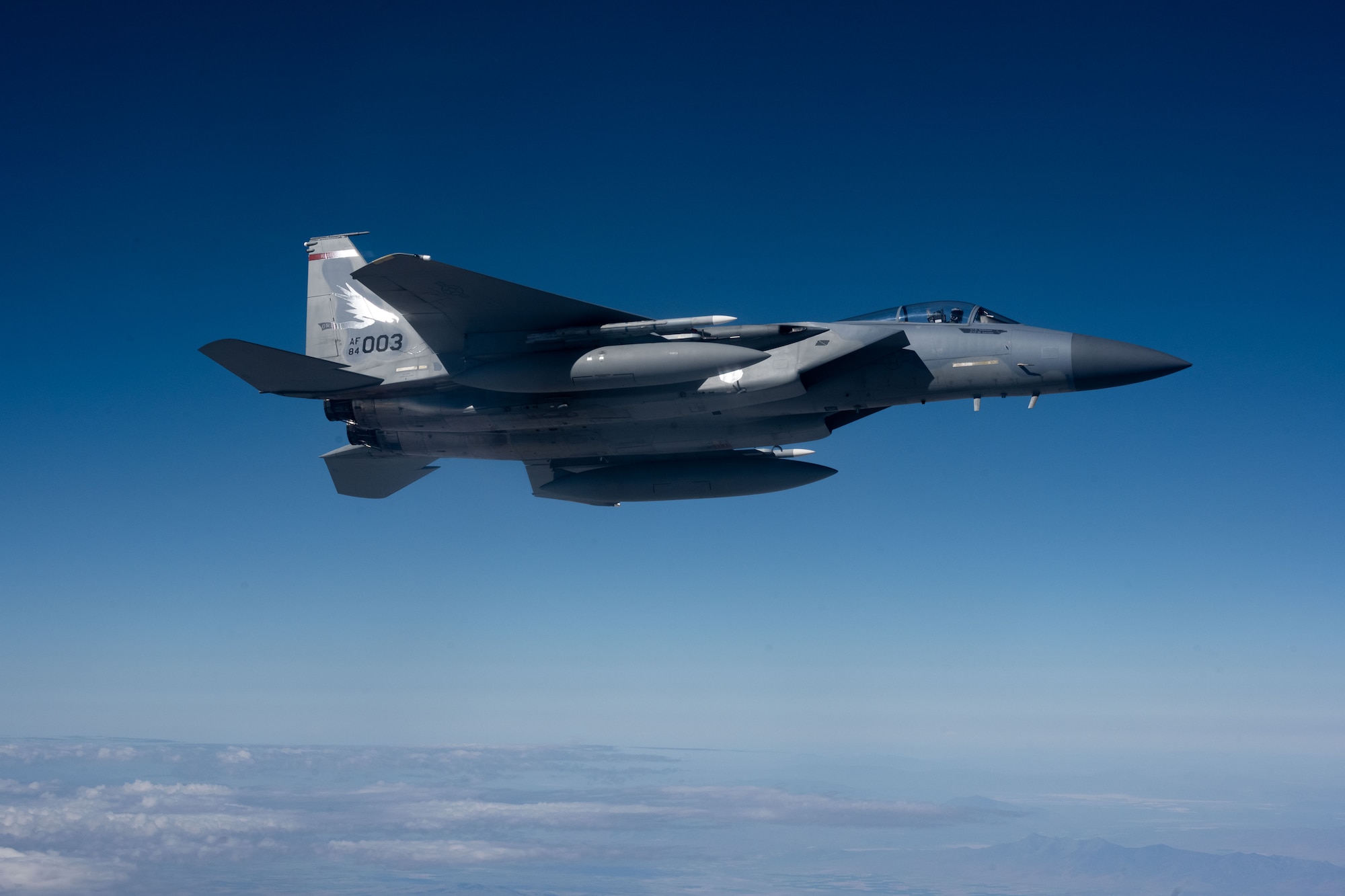 A F-15 jet aircraft is flying high in the sky.