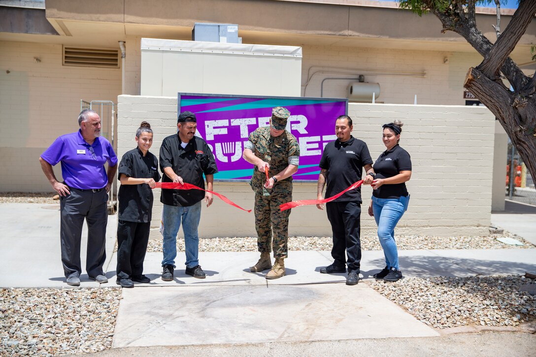 Marine Corps Air Station Yuma Commanding Officer, Col Charles E. Dudik, alongside MCCS personnel, cuts the ribbon in honor of the official opening of the Afterburner restaurant aboard MCAS Yuma, Ariz., June 10, 2021.
