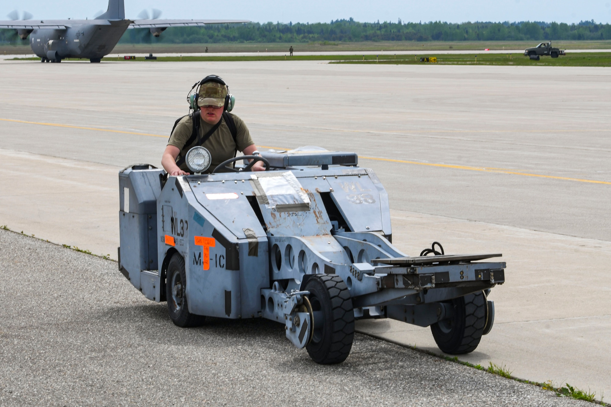 A photo of an airman driving a bomb lift