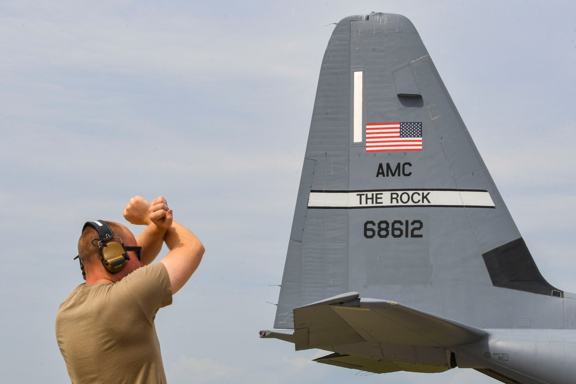A photo of an airmen signaling an aircraft to halt
