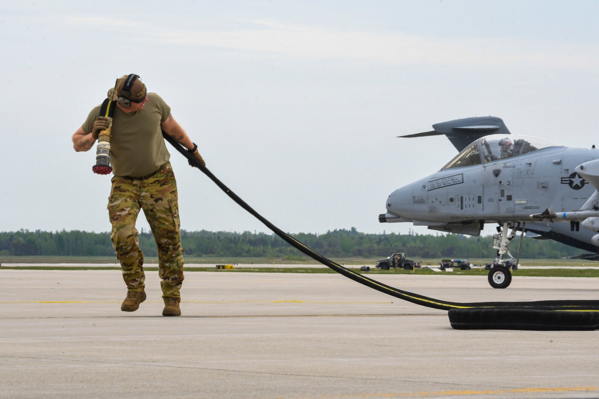 A photo of an airman carrying a fueling nozzle