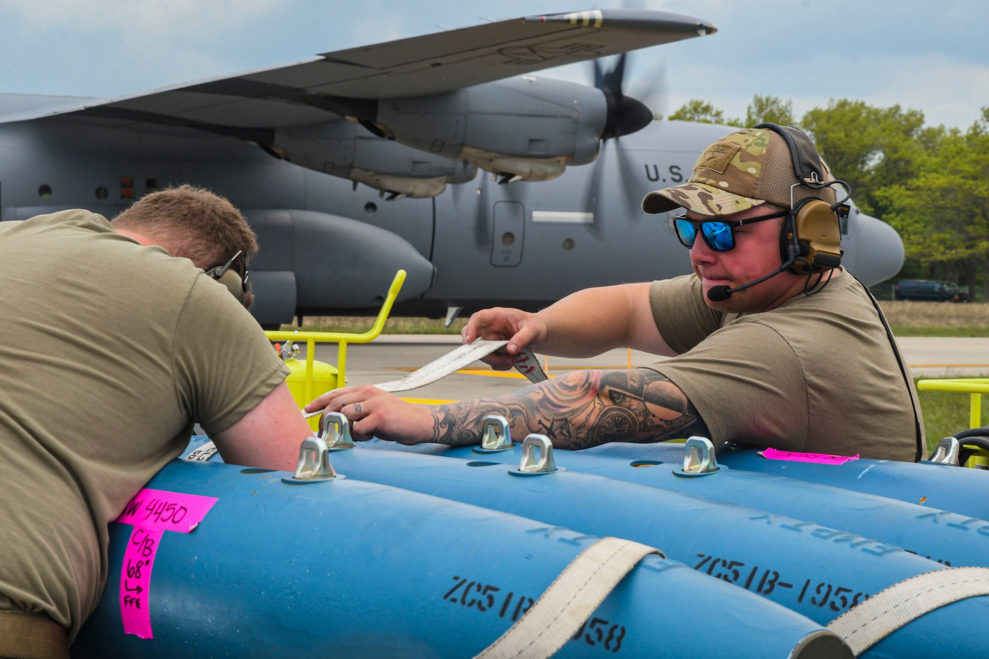 A photo of two airmen prepping munitions for loading