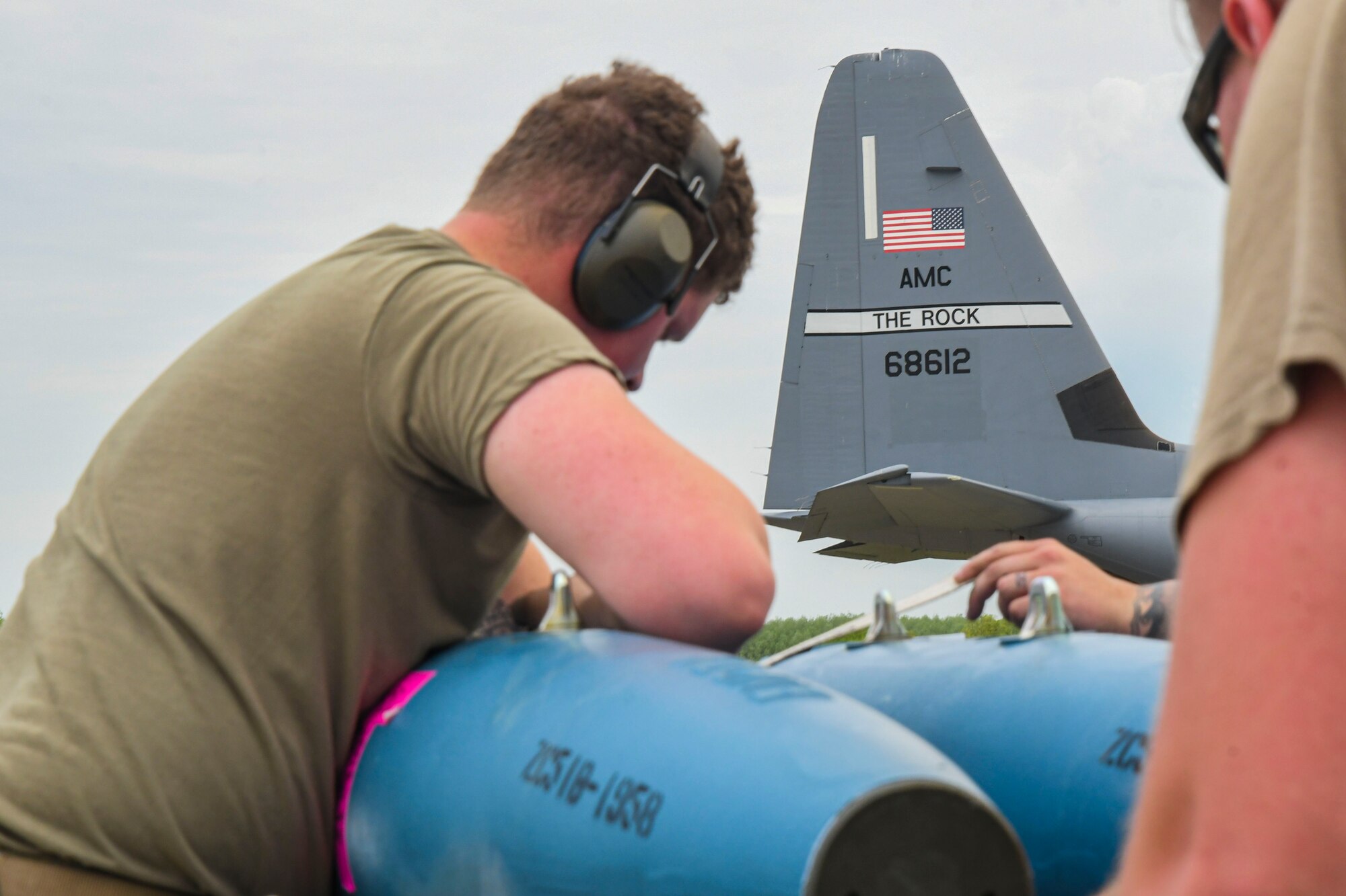 A photo of an airmen prepping munitions for loading