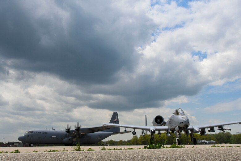 A photo of two aircraft on a flight line