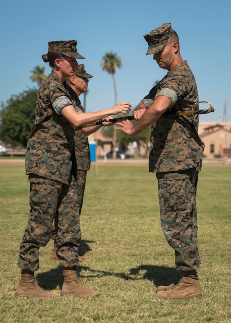 U.S. Marine Corps Lt. Col. Andrea Goeman passes the sword to Master Gunnery Sgt. Leon Harpel on Marine Corps Air Station Yuma, Ariz., June 11, 2021. The passing of the sword symbolizes the relief of duty from Sgt Maj. George Hernandez. (U.S. Marine Corps photo by Lance Cpl. Carlos Kealy)