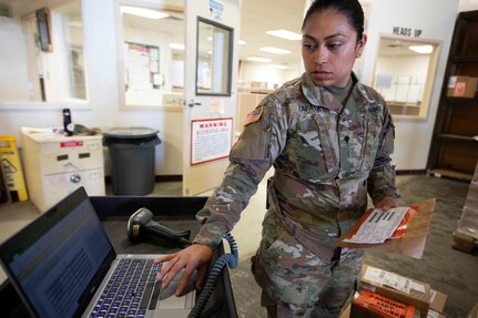 Alaska Army Guard Spc. Elvira Zapata, United States Property and Fiscal Offices Supply Support Activity, scans supplies into an equipment log for accountability before processing at the USPFO warehouse on Joint Base Elmendorf-Richardson, June 7, 2021. (U.S. Army National Guard photo by Victoria Granado)