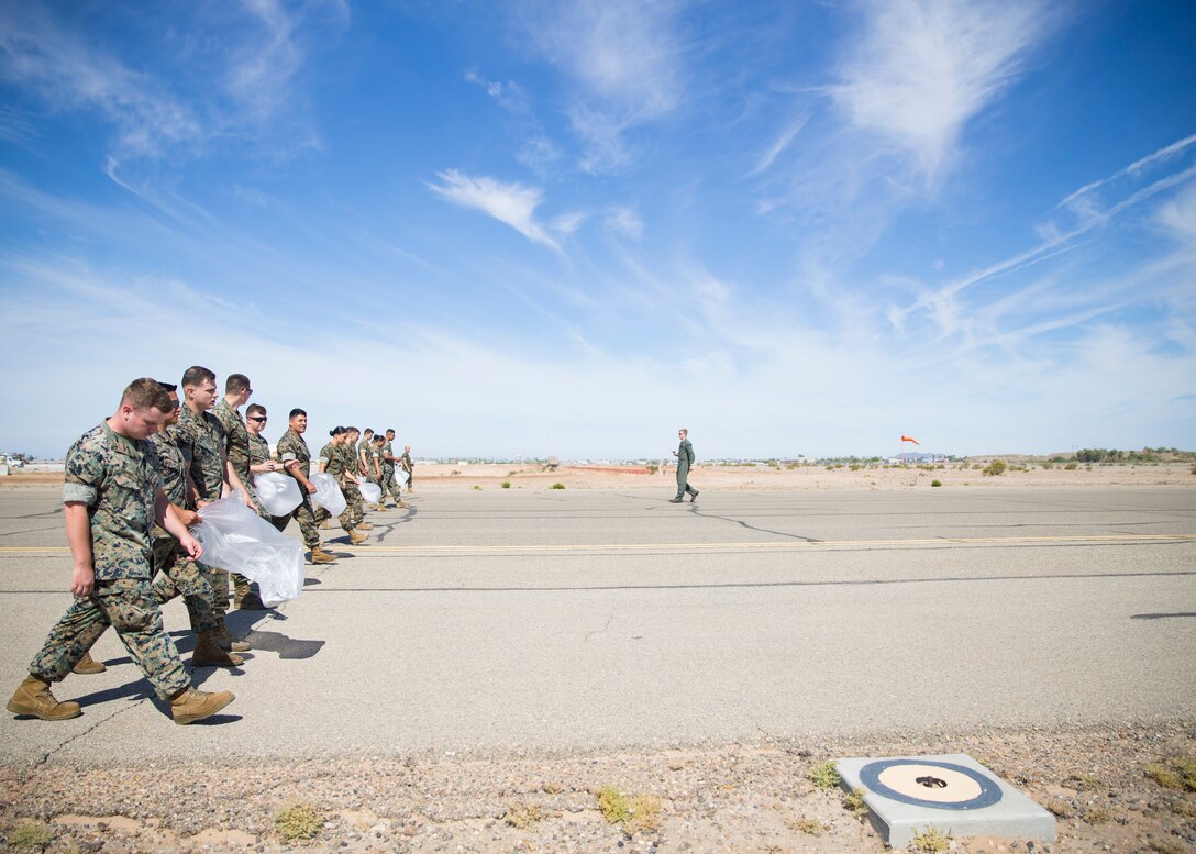 U.S. Marines conduct a Foreign Object Debris (FOD) walk along the runway at Marine Corps Air Station Yuma, Ariz., June 7, 2021. A FOD walk is conducted routinely to make sure runways are clear from debris that may damage aircraft using it. (U.S. Marine Corps Photo by Lance Cpl Matthew Romonoyske-Bean)