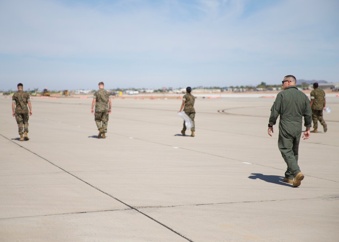 U.S. Marine Corps Capt. Richard Hetrick, an aviation safety officer with Headquarters and Headquarters Squadron, oversees Marines conducting Foreign Object Debris (FOD) walk at Marine Corps Air Station Yuma, Ariz., June 7, 2021.