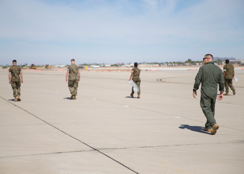 U.S. Marine Corps Capt. Richard Hetrick, an aviation safety officer with Headquarters and Headquarters Squadron, oversees Marines conducting Foreign Object Debris (FOD) walk at Marine Corps Air Station Yuma, Ariz., June 7, 2021.  A FOD walk is conducted routinely to make sure runways are clear from debris that may damage aircraft using it. (U.S. Marine Corps Photo by Lance Cpl Matthew Romonoyske-Bean)