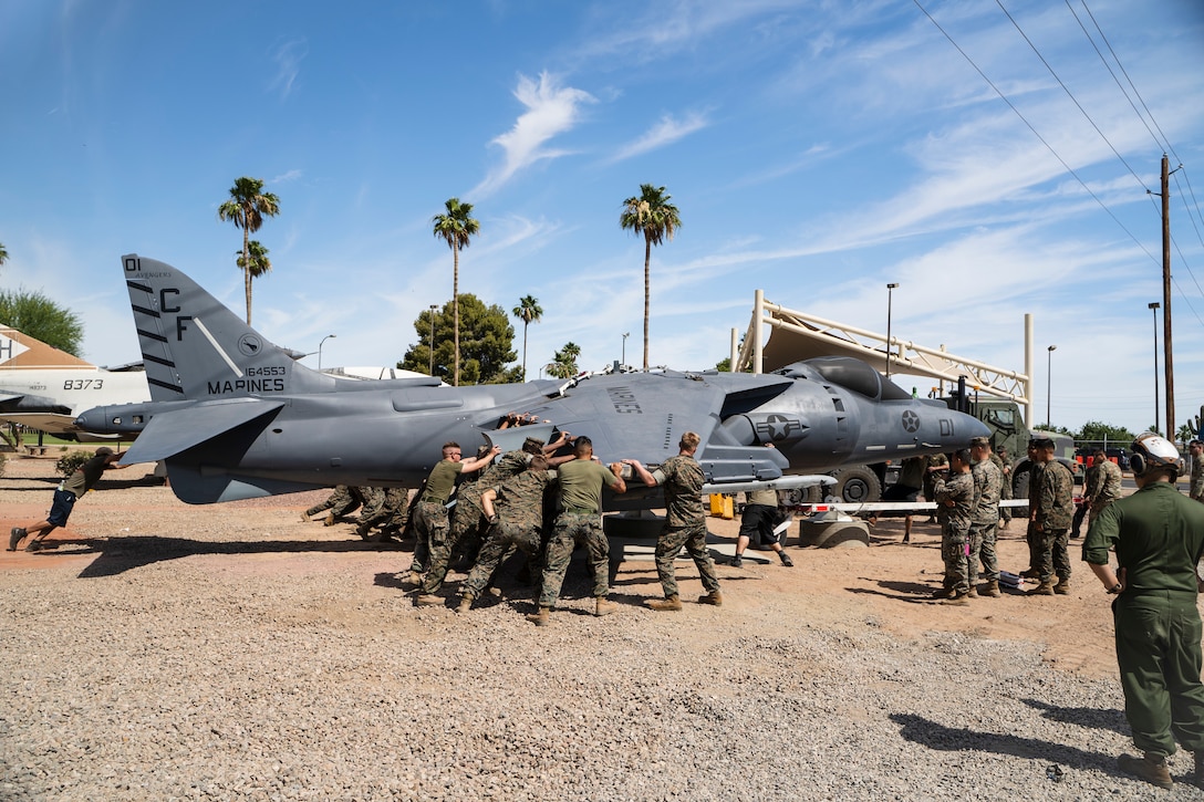 U.S. Marines from Marine Wing Support Squadron 371 push an AV-8B Harrier jet into a static display area on Marine Corps Air Station Yuma, June 7, 2021. The new display is located next to the main gate to help preserve Marine Corps aviation history and tradition.(U.S. Marine Corps photo by Lance Cpl. Carlos Kealy)