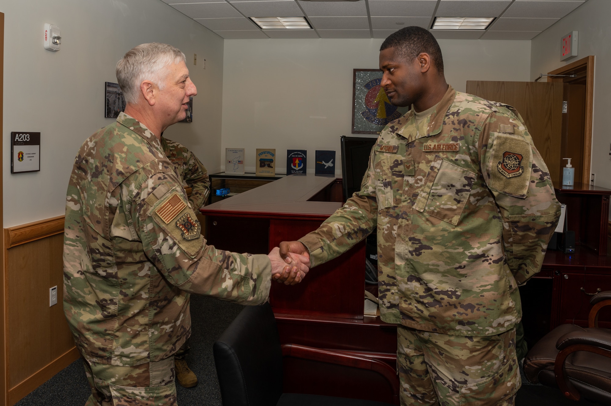 The U.S. Air Force Expeditionary Center Commander, Maj. Gen. Mark Camerer, left, coins Staff Sgt. Percy Mitchell, 731st Air Mobility Squadron commander's executive assistant, at Osan Air Base, May 19, 2021. The leadership team recognized many high performing Airmen with a challenge coin. (U.S. Air Force photo by Senior Airman Branden Rae)