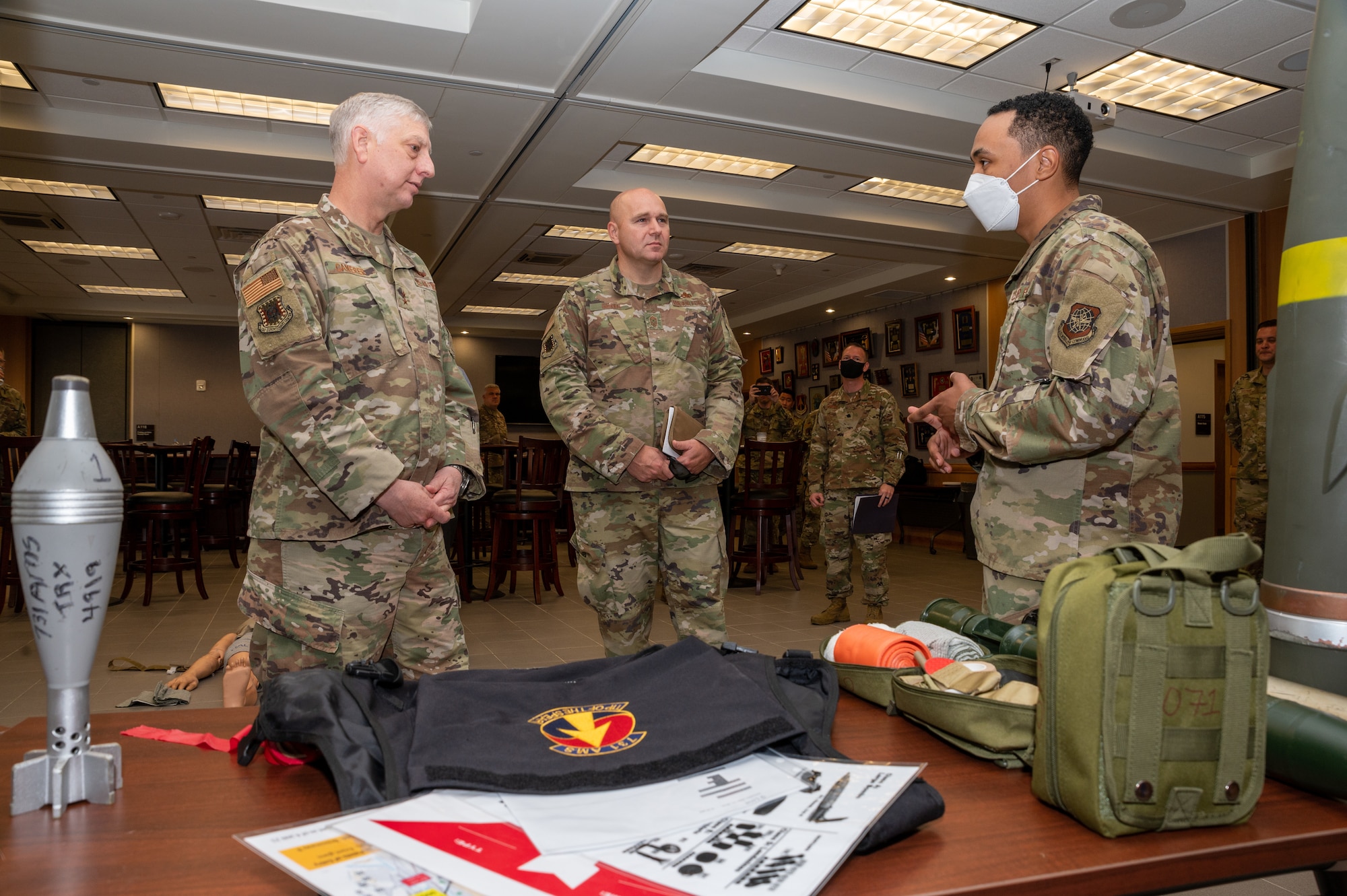 The U.S. Air Force Expeditionary Center Commander, Maj. Gen. Mark Camerer, left, and the USAF Expeditionary Center Command Chief, Chief Master Sgt. Anthony Green, middle, receive a brief from Staff Sgt. Frederick Smith, 731st Air Mobility Squadron unit training manager, at Osan Air Base, May 19, 2021. Smith demonstrated the training activities involved with living at Osan AB. (U.S. Air Force photo by Senior Airman Branden Rae)