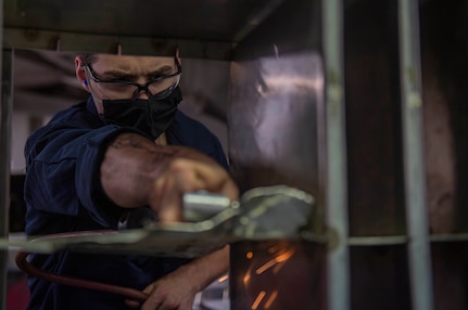 Aviation Structural Mechanic Airman Apprentice Craig Campbell, from Tallahassee, Florida, assigned to Fleet Readiness Center Norfolk, uses a grinder wheel to remove a metal plate in the jet shop aboard the Nimitz-class aircraft carrier USS Harry S. Truman (CVN 75) during Tailored Ship's Training Availability (TSTA) and Final Evaluation Period (FEP).