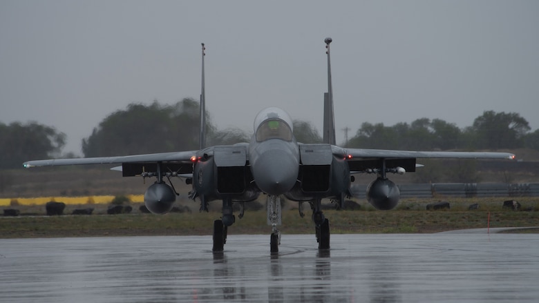 This is a picture of a F-15 jet aircraft on a flight line runway.