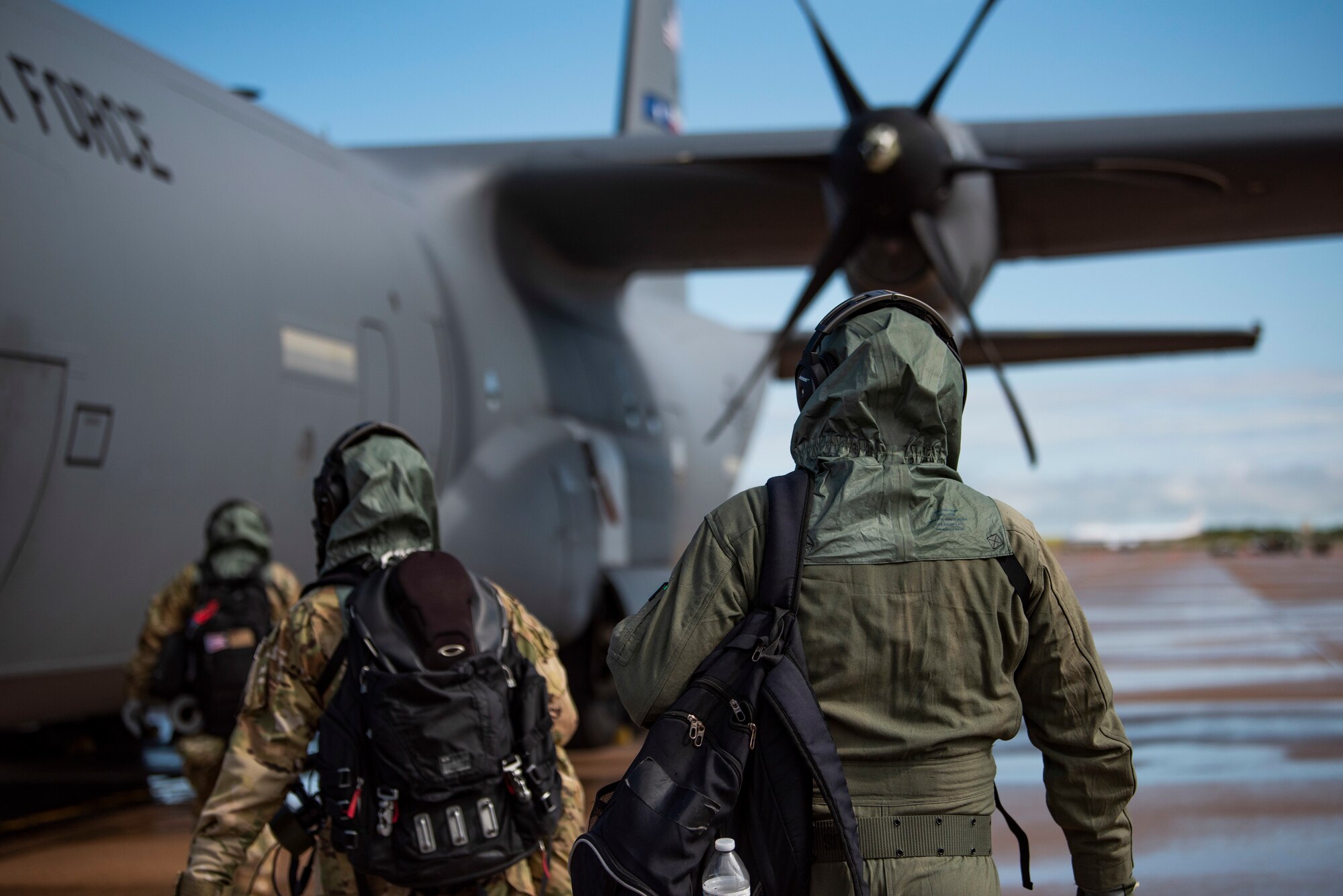 1st Lt. Coltan Nading, 40th Airlift Squadron pilot, right, Capt. Miranda Mila, 40th AS pilot, center, and Staff Sgt. Tristan Geray, 40th AS loadmaster, approach a C-130J Super Hercules at Dyess Air Force Base, Texas, June 2,2021. The aircrew simulated aircraft preflight checks and conducted a ground egress in order to field test the new Two-Piece Undergarment chemical suit. (U.S. Air Force photo by Airman 1st Class Colin Hollowell)