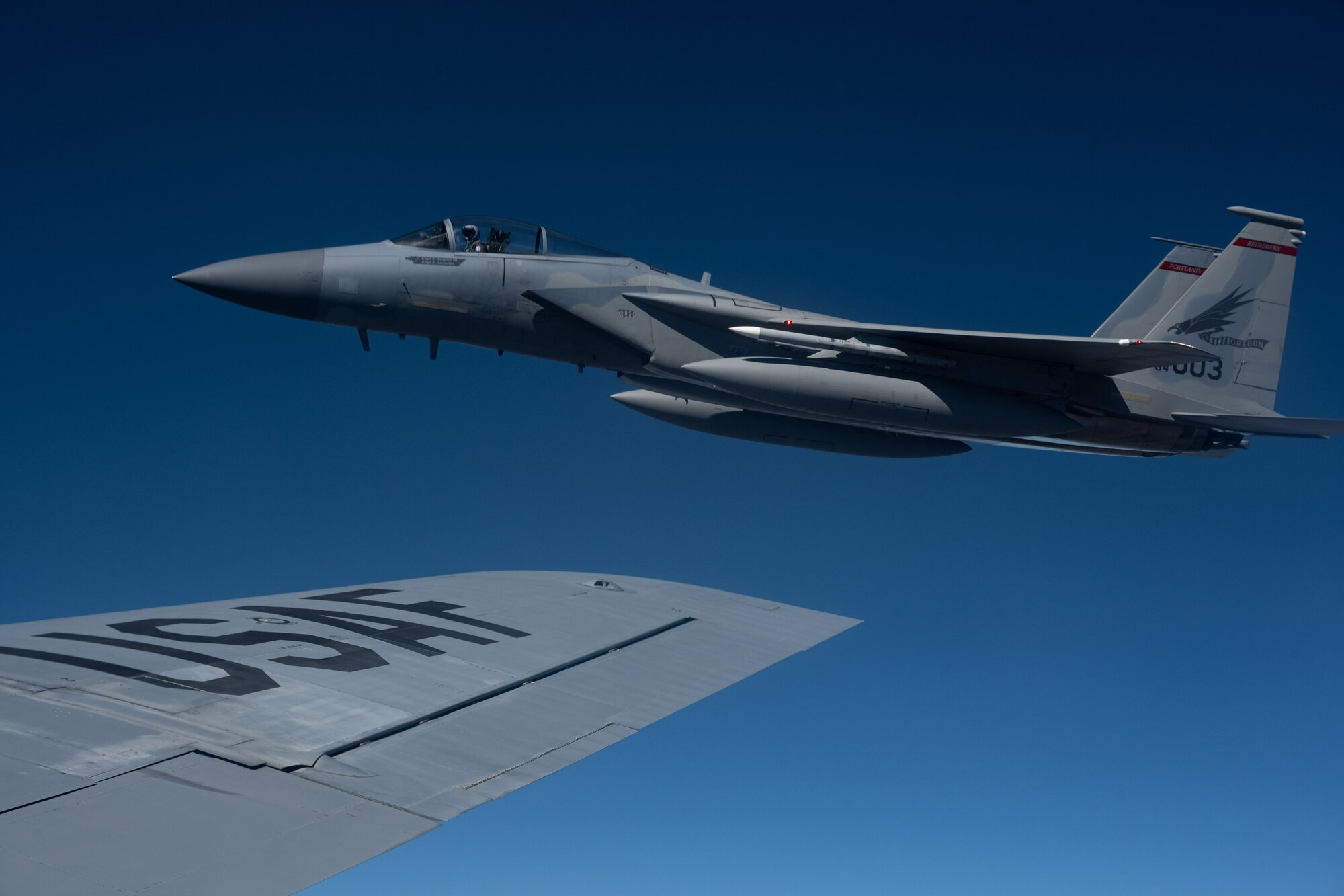 A F-15 jet aircraft flies next to KC-135 Startotanker