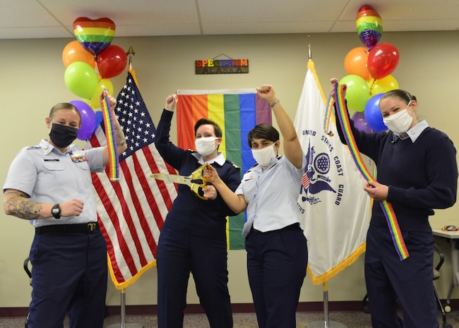 Petty Officer 2nd Class Carla Evans (left to right), Lt. Sarah Gomez-Lorraine, Capt. Leanne Lusk and Petty Officer 2nd Class Melissa McKenzie celebrate immediately after a ribbon-cutting ceremony held at Coast Guard Sector Anchorage, April 16, 2021, marking the establishment of the Coast Guard Spectrum Northern Lights Chapter. The Spectrum Northern Lights Chapter is an affinity group representing the LGBTQIAP+ community, as well as their friends, family, allies and advocates in Alaska and beyond. U.S. Coast Guard photo by Petty Officer 1st Class Nate Littlejohn.