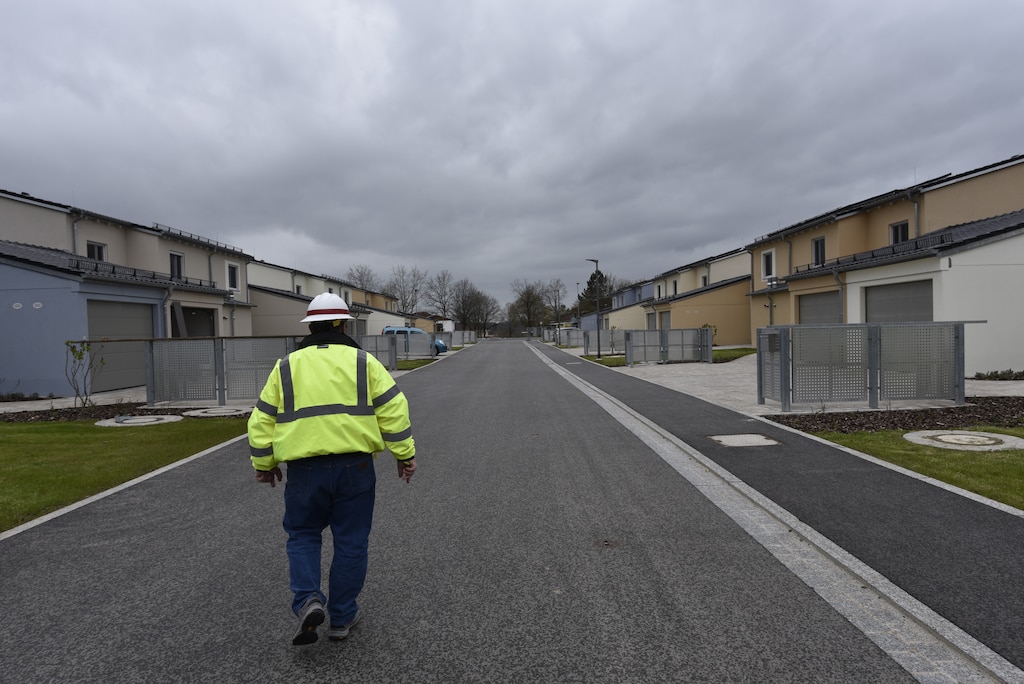 U.S. Army Corps of Engineers, Europe District Project Engineer John Taylor walks down a new street past several recently completed and nearly completed homes May 6, 2021 in the Kittenberg Housing Area on Rose Barracks in Vilseck, Germany, which is part of U.S. Army Garrison Bavaria. The U.S. Army Corps of Engineers is delivering 29 family homes, including associated infrastructure like drainage, utilities and roads in a newly built neighborhood for Soldiers and their families. The homes are part of a larger, long-term collaboration between the U.S. Army Corps of Engineers and the garrison to provide new and renovated family housing and other quality of life projects for Soldiers and their families at Rose Barracks.