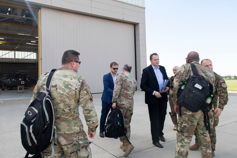 U.S. Army Maj. Gen. Paul Rogers, right, adjutant general and director of the Michigan Department of Military and Veterans Affairs, and Command Sgt. Maj. William Russell III, senior enlisted advisor, Michigan National Guard, shake hands with the Latvian delegates at the end of the key leadership engagement between Latvian National Armed Forces (LNAF) and the Michigan National Guard (MING)