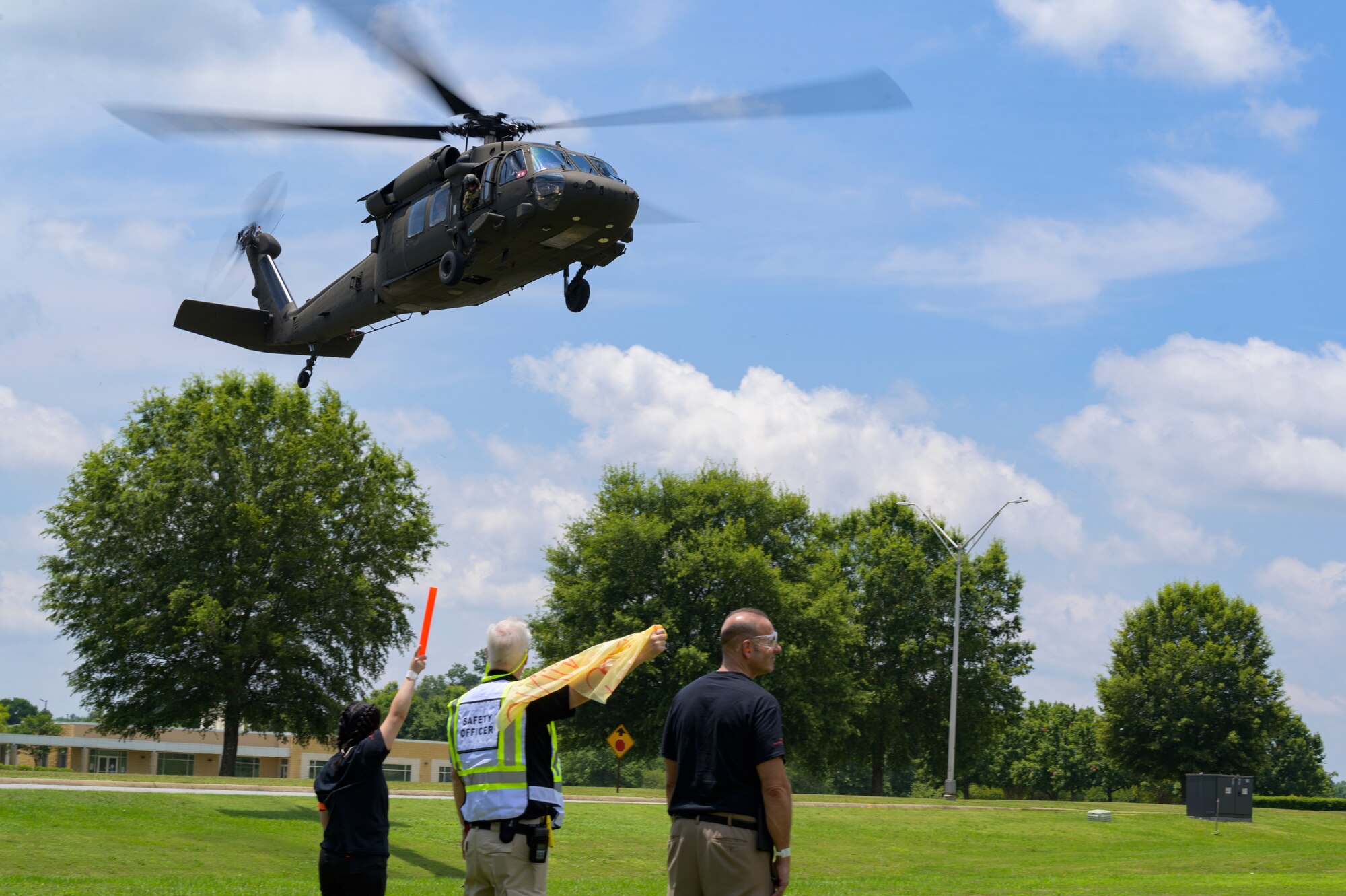 Members of the helicopter landing crew guide in a UH-60 Black Hawk helicopter to a landing zone at Central Georgia Technical College, Warner Robins, Georgia, June 12, 2021.