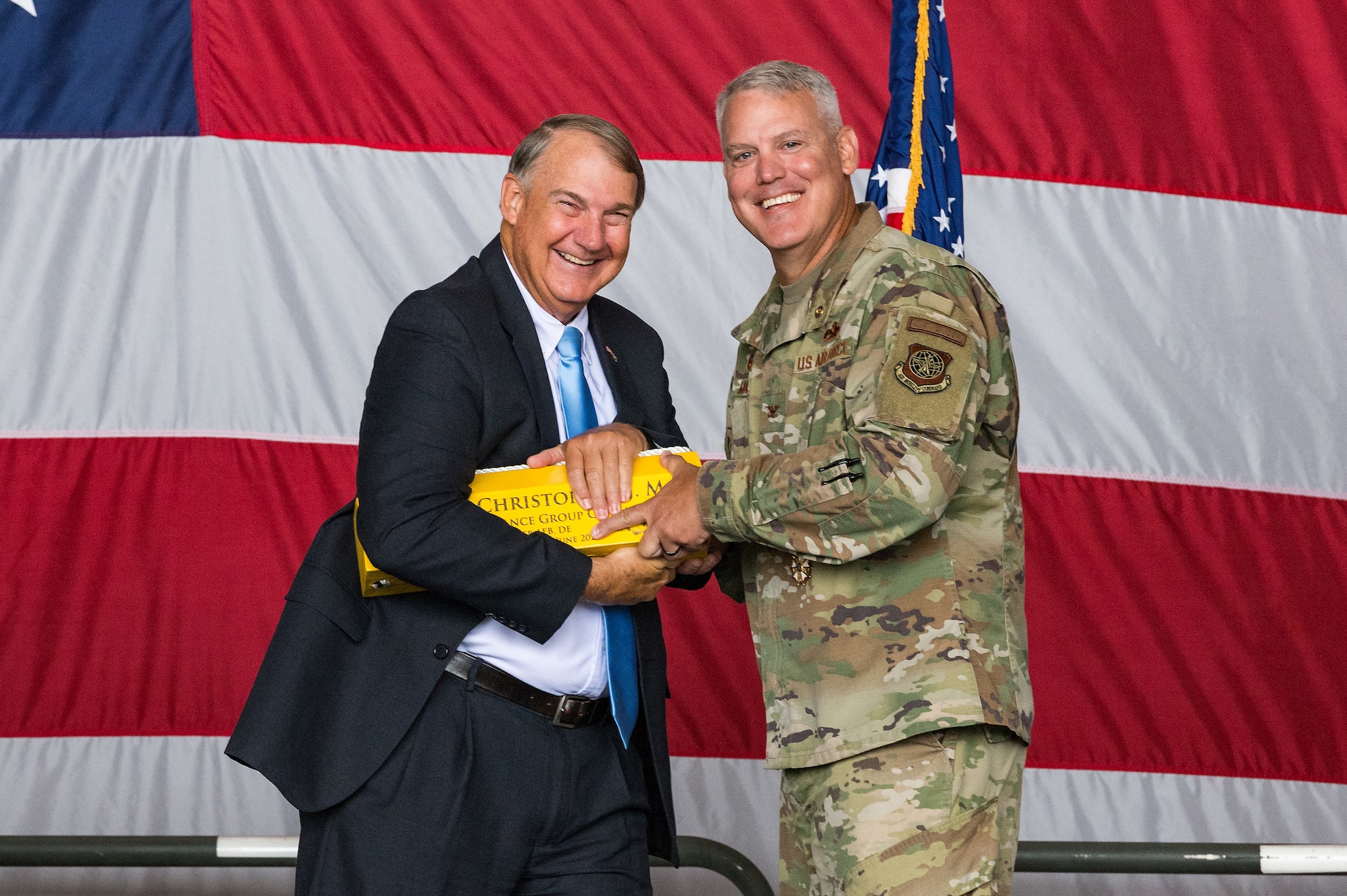 Retired Air Force Col. Norman Moore, left, and Col. Christopher May, 436th Maintenance Group commander, pose for a photo during a ceremony at Dover Air Force Base, Delaware, June 11, 2021. Moore officiated the ceremony, which paid special tribute to May's distinguished career spanning 33 years. Moore presented May with an aircraft chock representing his time at Dover AFB. (U.S. Air Force photo by Roland Balik)