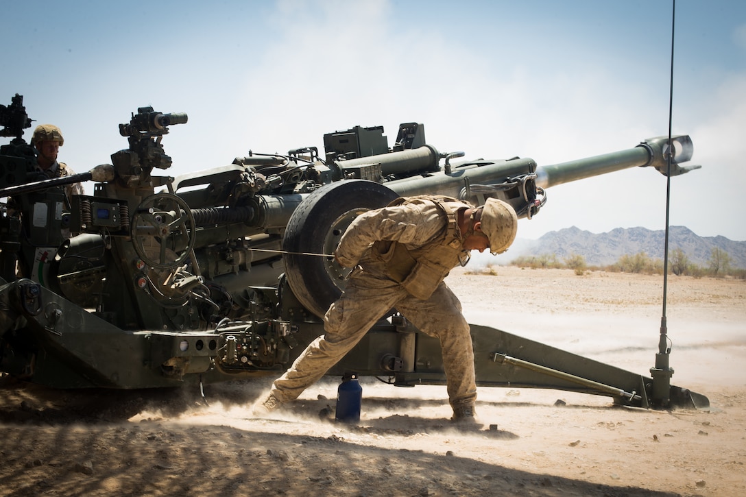 U.S. Marine Corps Cpl. Elijah Feliciano, an assistant gunner with 2nd Battalion, 11th Marines, 1st Marine division (MARDIV), pulls the firing cord on an M777 towed 155mm howitzer during exercise Summer Fury, at Range 2057 South, Calif., Aug. 1, 2018. The exercise was conducted to increase 1st MARDIV operations proficiency by incorporating establishing, transitioning and phasing control of aircraft and missiles across multiple locations. (U.S. Marine Corps photo by Lance Cpl. Audrey M. C. Rampton)