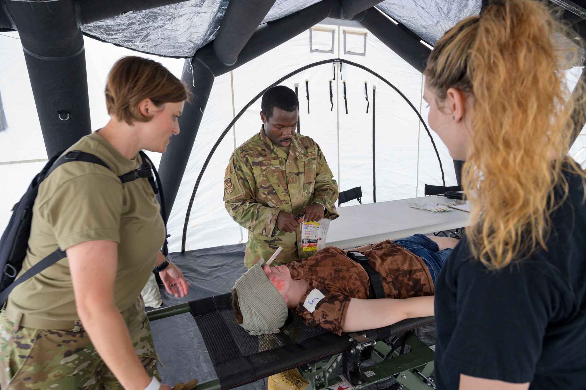 U.S. Airmen with the 116th Medical Group, Detachment 1, Georgia Air National Guard, and a civilian medical student prepare to transport patient with simulated injuries at Central Georgia Technical College, Warner Robins, Georgia, June 11, 2021. Nearly 50 personnel with the 116th MDG, Det 1, trained with civilian medical professionals and local authorities to respond to a mass casualty scenario in a two-day exercise. (U.S. Air National Guard photo by Airman 1st Class Josiah Meece)