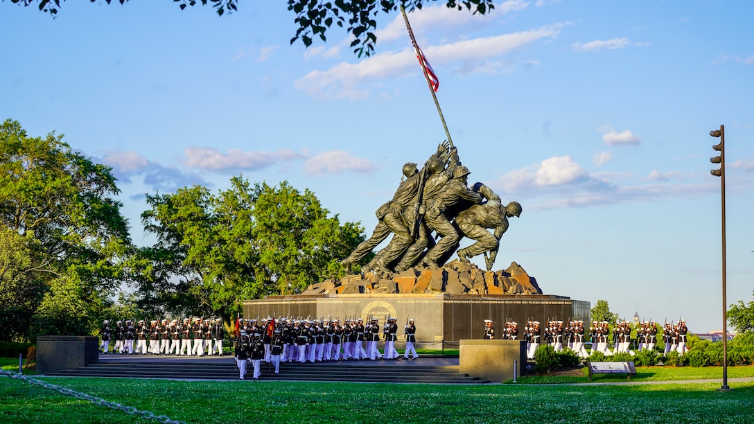 Marines with Marine Barracks Washington march onto the parade deck during a Tuesday Sunset Parade at the Marine Corps War Memorial, Arlington, VA, June 15, 2021. The hosting official for the evening was Brig. Gen. Lorna Mahlock, Director, Information, Command, Control, Communications and Computers, and Ms. Gwynne Shotwell, President and Chief Operations Officer of SpaceX, was the guest of honor. (U.S. Marine Corps photo by Sgt. Jason Kolela)