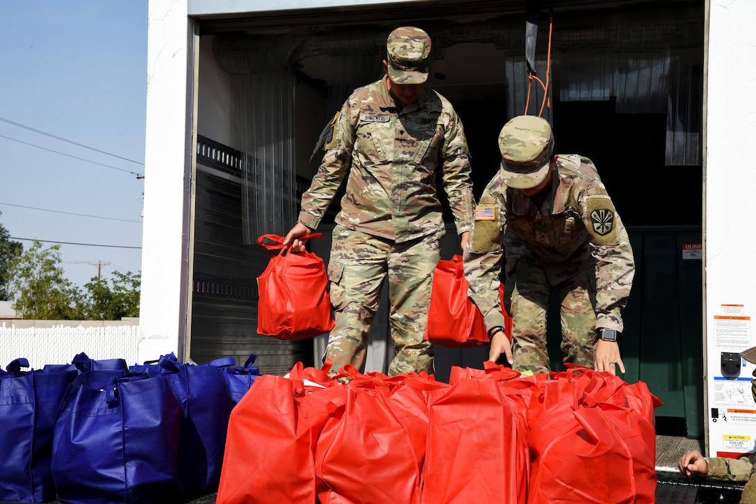 Soldiers unload bags of groceries that will be delivered to residents in the area.