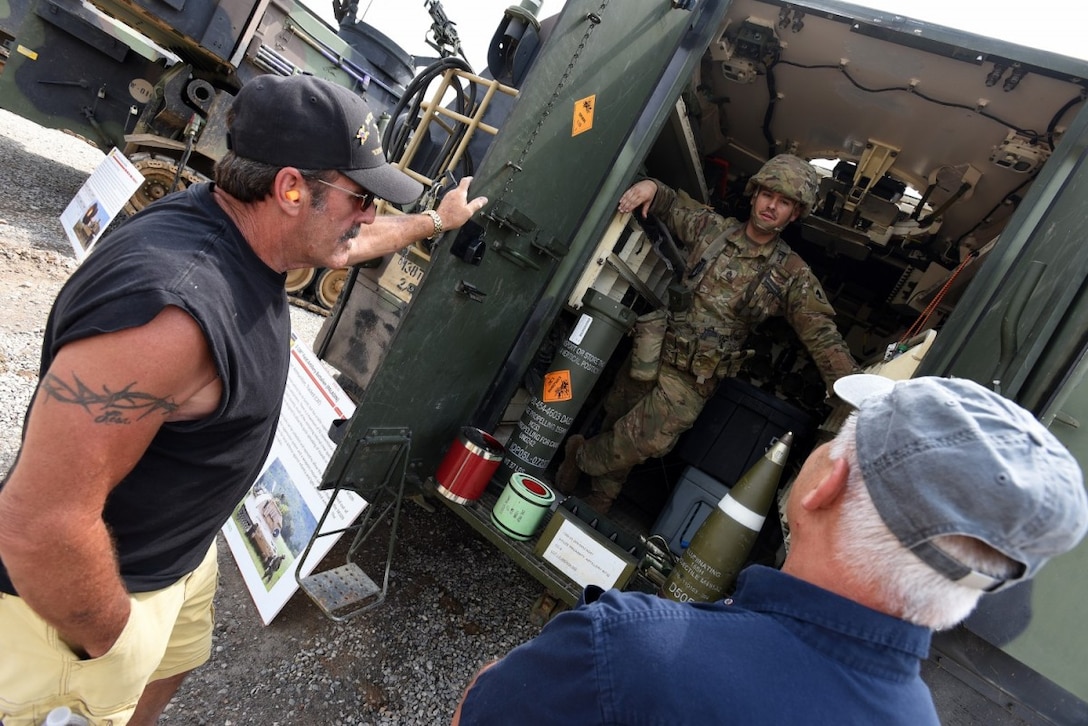 A Soldier with 2nd Battalion, 138th Field Artillery (Paladin), talks shop with former members of the unit about the Paladin’s capabilities. (Eric Pilgrim, Fort Knox News)