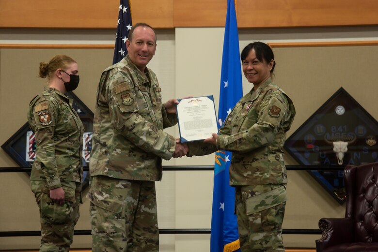 Col. Mark Pomerinke, 341st Medical Group commander, and Lt. Col. Michelle Dimoff, 341st Operational Medical Readiness Squadron outgoing commander, pose for a photo as Dimoff receives the meritorious service medal during a change of command ceremony June 16, 2021 at Malmstrom Air Force Base, Mont.