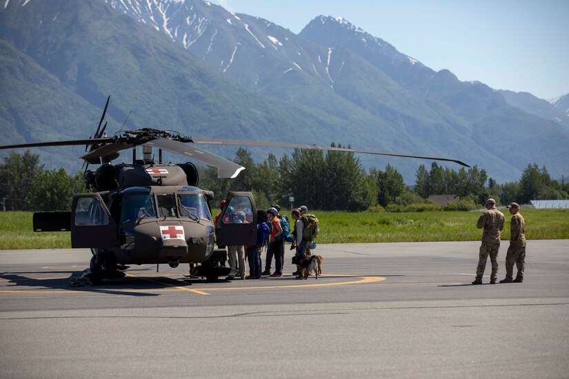 Pilots and crew members of the Alaska Army National Guard's 1st Battalion, 207th Aviation Regiment prepare to fly ground search and rescue teams with Alaska Mountain Rescue Group and MAT+SAR Search & Rescue to various locations on Pioneer Peak near Palmer, AK, to search for a missing hiker, June 15, 2021. (U.S. Army National Guard photo by Spc. Grace Nechanicky)