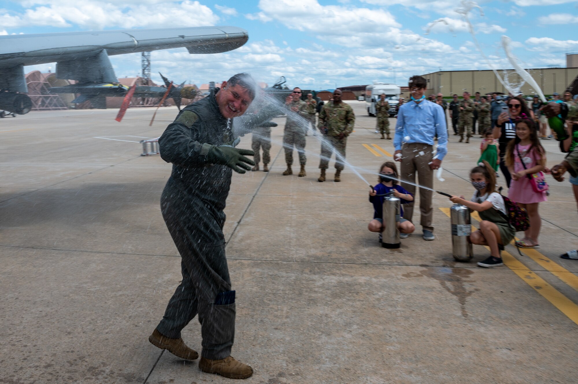 U.S. Air Force Col. John Gonzales, 51st Fighter Wing commander, is sprayed with water by his children after his final A-10 Thunderbolt II flight at Osan Air Base, Republic of Korea, June 16, 2021. Gonzales' family and friends met him on the flightline to celebrate this event. (U.S. Air Force photo by Senior Airman Branden Rae)