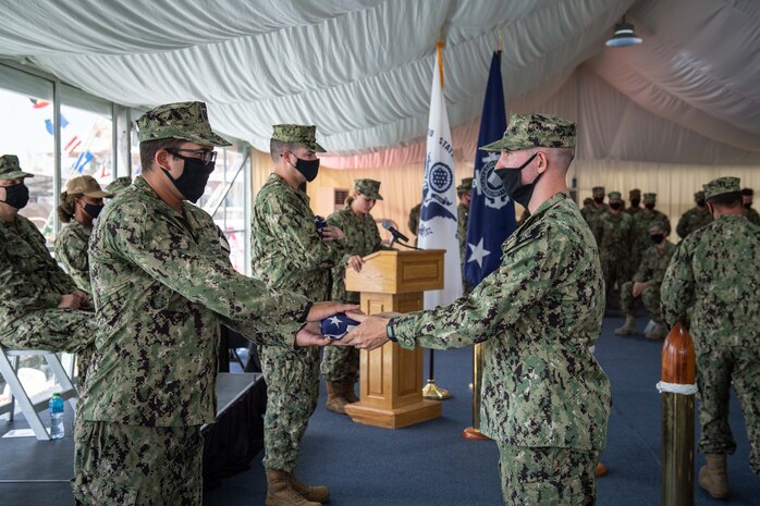 210615-N-KZ419-1229 NAVAL SUPPORT ACTIVITY BAHRAIN (June 15, 2021) Coast Guardsmen present pennants from the USCGC Adak (WPB 1333) and USCGC Aquidneck (WPB 1309) during the decommissioning ceremony for Adak and Aquidneck onboard Naval Support Activity Bahrain, June 15. Adak and Aquidneck operated in the U.S. 5th Fleet area of operations since 2003 in support of Operation Iraqi Freedom, Enduring Freedom, Inherent Resolve and Spartan Shield. (U.S. Navy photo by Mass Communication Specialist 3rd Class Dawson Roth)