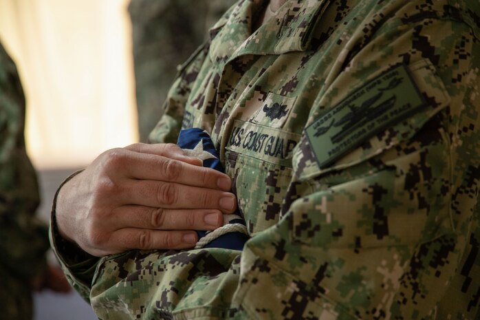 210615-N-ZA692-1371 NAVAL SUPPORT ACTIVITY BAHRAIN (June 15, 2021) Chief Machinery Technician Jeremiah McGeehan, assigned to USCGC Aquidneck (WPB 1309), holds his ships Union Jack during the decommissioning ceremony for USCGC Adak (WPB 1333) and Aquidneck onboard Naval Support Activity Bahrain, June 15. Adak and Aquidneck operated in the U.S. 5th Fleet area of operations since 2003 in support of Operation Iraqi Freedom, Enduring Freedom, Inherent Resolve and Spartan Shield. (U.S. Navy photo by Mass Communication Specialist 2nd Class Anita Y. Chebahtah)