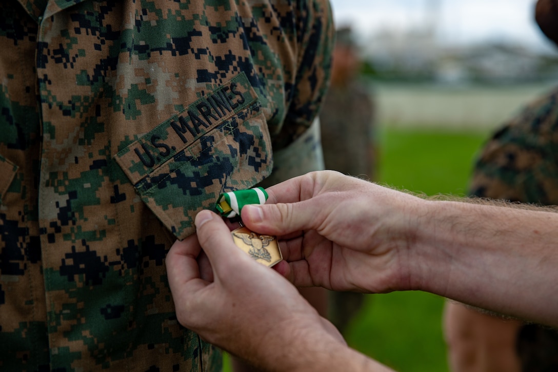 U.S. Marine Corps Master Gunnery Sgt. Ronald Thomas, the distribution management chief with III Marine Expeditionary Force, receives the Navy and Marine Corps Commendation Medal on June 15, 2021. Thomas and his wife, Master Sgt. Sara Thomas, the G-2 plans chief with III MEF, received medals for their heroic actions at Ta-Taki Falls on Sept. 13, 2020. (U.S. Marine Corps photo by Lance Cpl. Natalie Greenwood)