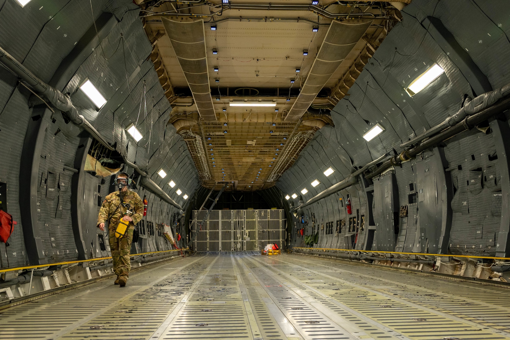Airman 1st Class Joshua Grant, 9th Airlift Squadron loadmaster, performs a cargo compartment check on a C-5M Super Galaxy while wearing a 358 Quick Don Demist oxygen mask, June 15, 2021. The 9th AS aircrew tested mask modifications for Air Mobility Command’s test and evaluation team which will assist in determining further modifications. (U.S. Air Force photo by Senior Airman Faith Schaefer)