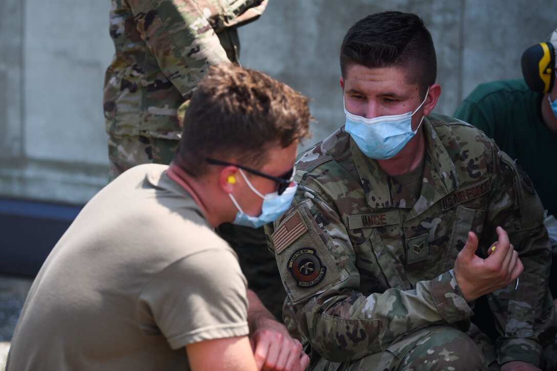 Senior Airman Tyler J. Vance, 31st Civil Engineer Squadron (CES) structural journeyman, right, train Airman Bryce E. Schneider, 31st CES structural apprentice, about harden aircraft shelter at Aviano Air Base, Italy, June 16, 2021. During the training the team replaced a guide roller to an apron door.  (U.S. Air Force photo by Senior Airman Ericka A. Woolever)