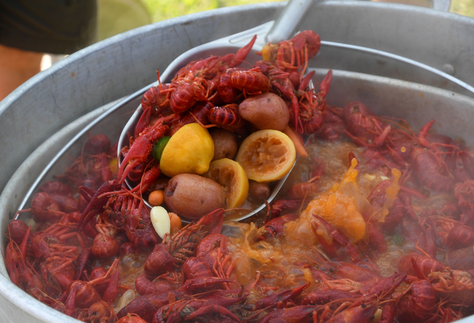 A pot of boiled crawfish and the "fixins" soak in seasonings during the 9th Annual Crawfish Cook-Off at the Bay Breeze Event Center at Keesler Air Force Base, Mississippi, June 11, 2021. Twelve teams competed in the event and more than 800 pounds of crawfish were distributed. (U.S. Air Force photo by Kemberly Groue)