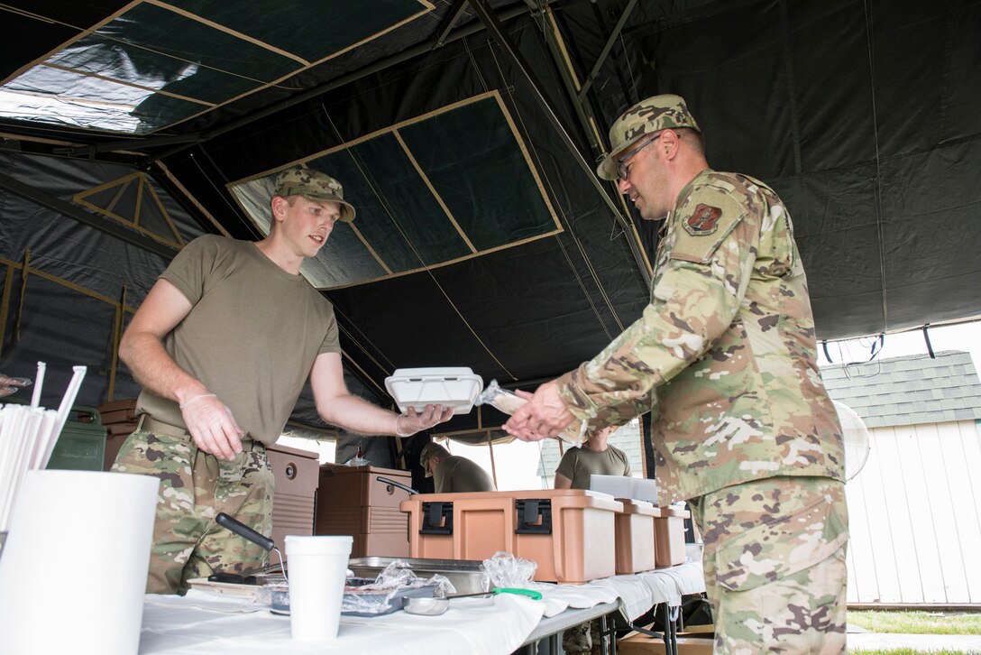 U.S. Air Force Staff Sgt. Jason Fauver, a services specialist with the 167th Force Support Squadron serves a field lunch to Senior Master Sgt. Rob Fluharty, a human resources advisor with the 167th Airlift Wing, in a single pallet expeditionary kit (SPEK) tent as part of field feeding operations during June’s unit training assembly at the 167th Airlift Wing, Martinsburg, West Virginia, June 9, 2021. The SPEK is a mobile, palletized kitchen that is designed to be loaded onto aircraft or vehicles and is able to be assembled by a crew of four in one hour.